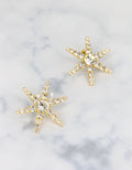 A pair of gold-colored starfish-shaped earrings adorned with crystals a fine summer beach jewellery